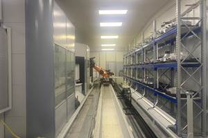 Pallet system with robotic arm on guide rail, pallets on shelves and two machine tools